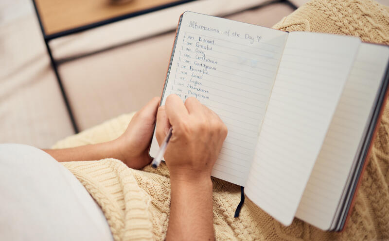 Woman writing in a notebook at home